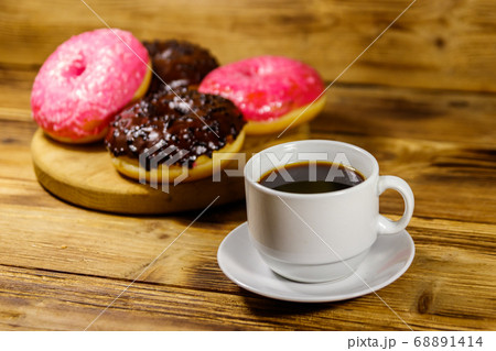 Cup of coffee and tasty donuts on a wooden table 68891414