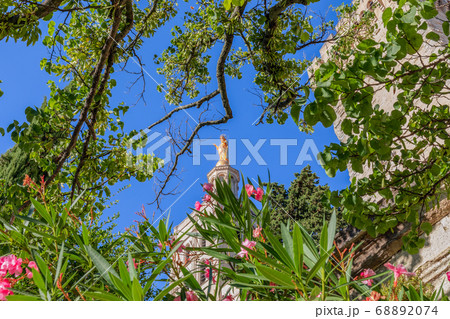 Statue of Golden Virgin Mary surrounded by flowers from the garden at the Palace 68892074