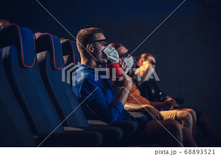 Cinema, movie theatre during quarantine. Coronavirus pandemic safety rules, social distance during movie watching Cinema, movie theatre during quarantine. Coronavirus pandemic safety rules, social distance during movie watching 68893521
