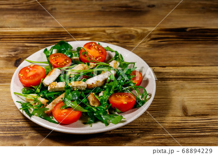 Tasty salad of fried chicken breast, fresh arugula Tasty salad of fried chicken breast, fresh arugula 68894229