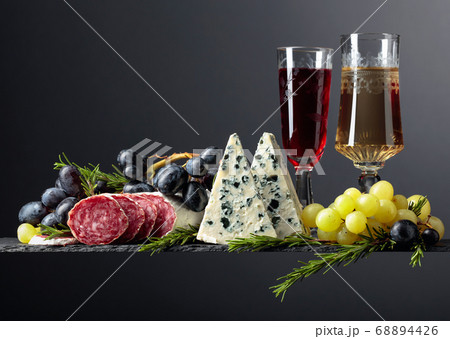 Red and white wine with snacks on a black 68894426