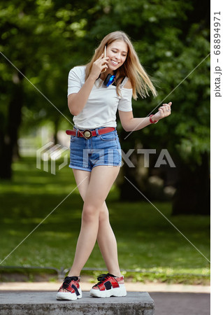 Attractive woman talks by phone outdoor. Attractive woman talks by phone outdoor. 68894971