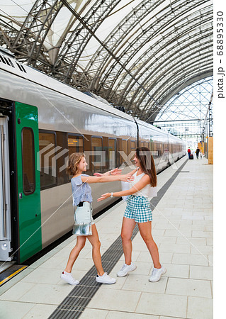 Happy meeting of two girlfriends near a modern 68895330