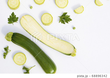 Composition of whole and sliced zucchini on a white background with space for text. Isolated vegetables on a white background. View from above 68896342