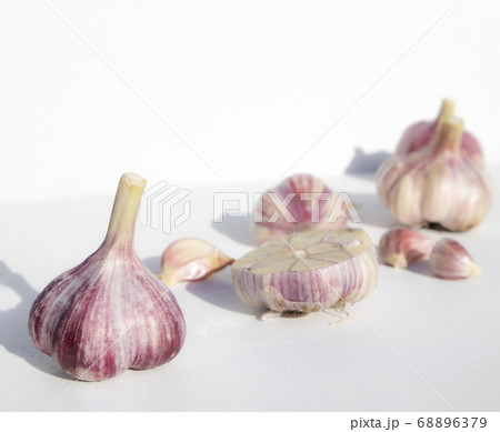 Whole garlic and cloves on a white background with space for text. Spicy food concept. Poster, menu. Whole garlic and cloves on a white background with space for text. Spicy food concept. Poster, menu. 68896379