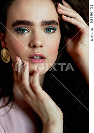 Portrait of a beautiful girl with long curly hair, natural thick eyebrows. In a pink dress.Natural beauty. Portrait of a beautiful girl with long curly hair, natural thick eyebrows. In a pink dress.Natural beauty. 68896451