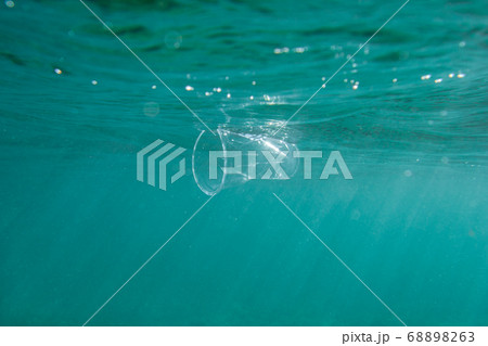 Plastic cup floats underwater in the open ocean. Environmental pollution concept. Plastic cup floats underwater in the open ocean. Environmental pollution concept. 68898263