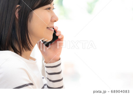 スマホで通話する女性 68904083