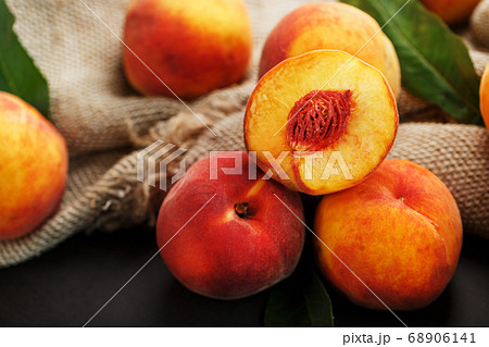 Peaches on a black background with burlap fabric Peaches on a black background with burlap fabric 68906141