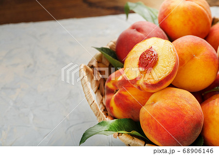 Peaches in a wicker basket on a stone gray table Peaches in a wicker basket on a stone gray table 68906146