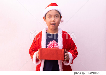 Asian boy in Santa Claus clothes holding gift 68906866