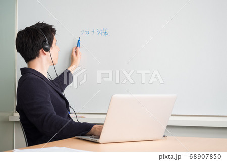 web会議でホワイトーボードに向かって文字を書く男性 68907850