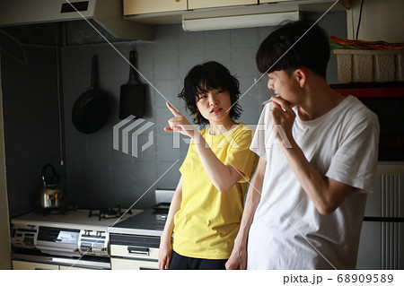 男性にベランダでタバコを吸うように注意する女性 68909589