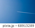 Flying passenger plane, blue sky with white trail 68913289