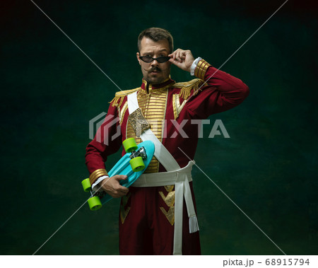 Young man as Nicholas II on dark green background. Retro style, comparison of eras concept. 68915794