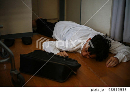 飲みすぎて玄関で寝る男性 68916953