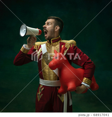 Young man as Nicholas II on dark green background. Retro style, comparison of eras concept. Young man as Nicholas II on dark green background. Retro style, comparison of eras concept. 68917041