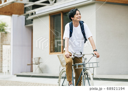 自転車に乗って出かける男性 68921194