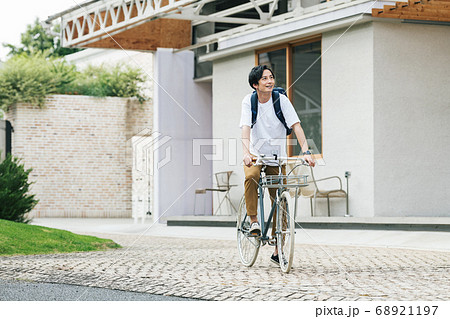 自転車に乗って出かける男性 68921197