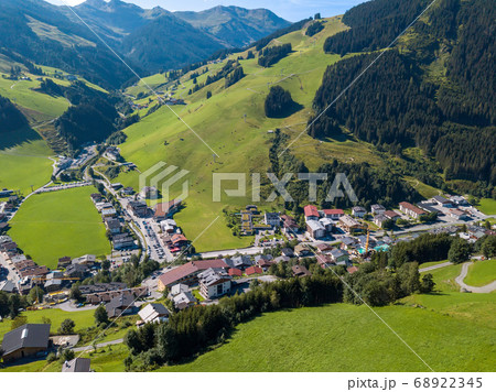 Aerial view of Hinterglemm village and mountains with skiing lifts in Saalbach-Hinterglemm skiing region in Austria on a beautiful summer day 68922345