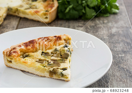 French quiche Lorraine with vegetables on a rustic wooden table	 68923248