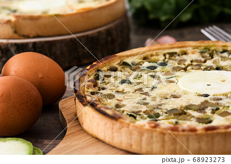French quiche Lorraine with vegetables on a rustic wooden table French quiche Lorraine with vegetables on a rustic wooden table 68923273