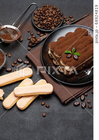 Classic tiramisu dessert and savoiardi cookies on ceramic plate on concrete background Classic tiramisu dessert and savoiardi cookies on ceramic plate on concrete background 68924819