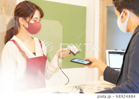 バーコードを読み取るマスク姿の女性店員 68924884