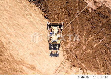Bulldozer pushing large amount of fresh soil, Aerial shot. 68925218