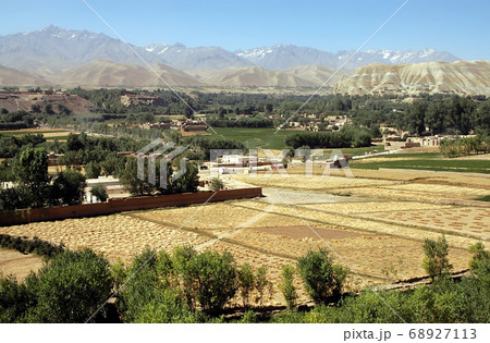 Bamyan (Bamiyan) in Central Afghanistan. A view over the Bamyan (Bamiyan) Valley showing the town, trees, fields and snow capped mountains. The town is home to the famous UNESCO Buddhas of Afghanistan Bamyan (Bamiyan) in Central Afghanistan. A view over the Bamyan (Bamiyan) Valley showing the town, trees, fields and snow capped mountains. The town is home to the famous UNESCO Buddhas of Afghanistan 68927113