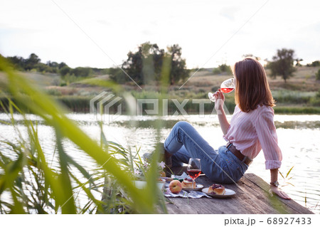 girl enjoying picnic on a wooden pie 68927433