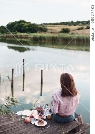 girl enjoying picnic on a wooden pie 68927435