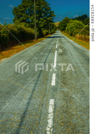Deserted road passing through rural landscape Deserted road passing through rural landscape 68928154