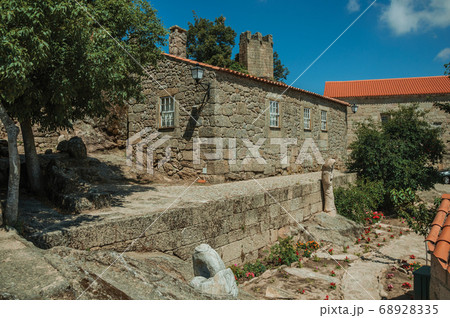 Houses made of stone and flowered garden 68928335