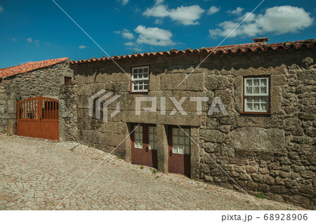 House made of stone with wooden door and deserted alley House made of stone with wooden door and deserted alley 68928906