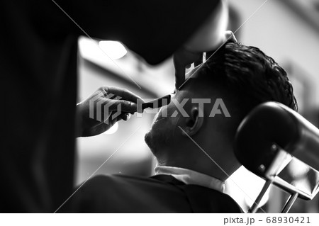 Vintage black and white photo of shaving beard in barber shop. Soft focus Vintage black and white photo of shaving beard in barber shop. Soft focus 68930421