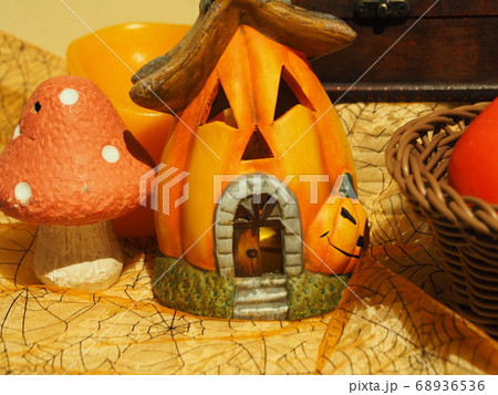 ハロウィンの笑っているカボチャの家と白ドットのあるオレンジ色のキノコの置物 68936536