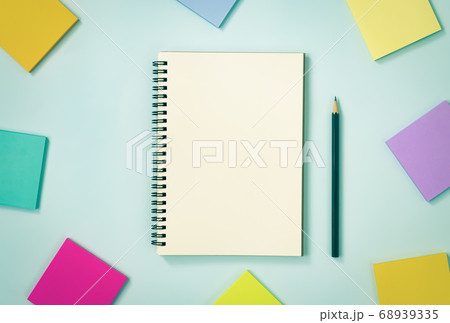 Spiral Notebook and Sticky Note and Pencil on Pastel Minimalist Background in Vintage Tone 68939335