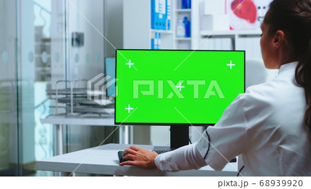 Doctor sits at computer with blank display Doctor sits at computer with blank display 68939920