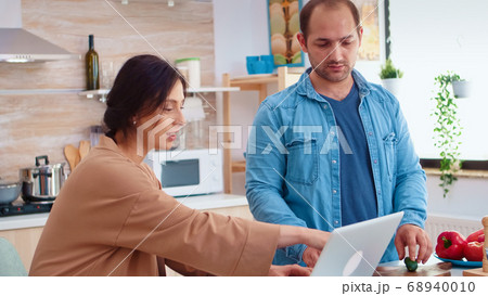 Man chopping tomatoes on wooden board 68940010