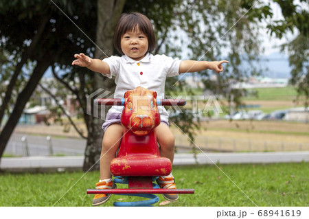 赤い馬のスプリング遊具で遊ぶ女の子 赤い馬のスプリング遊具で遊ぶ女の子 68941619