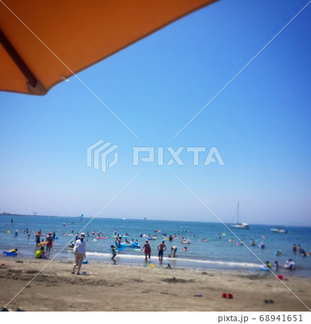 ビーチパラソルと海で遊ぶ人々　写真素材 68941651