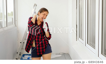 positive lady sings using brush as microphone on terrace 68943646