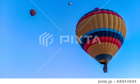 Colorful hot air balloons flying over the valley with fairy chimneys in winter season. Lots of Hot air balloons at the sunrise sky landscape in Cappadocia, Turkey Colorful hot air balloons flying over the valley with fairy chimneys in winter season. Lots of Hot air balloons at the sunrise sky landscape in Cappadocia, Turkey 68943694
