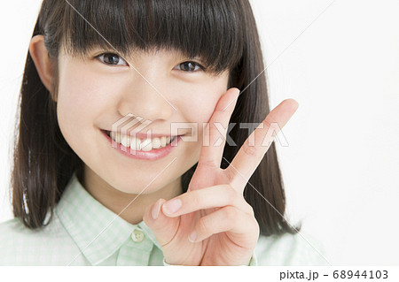 ピースサインをする女の子の写真素材 [68944103] - PIXTA