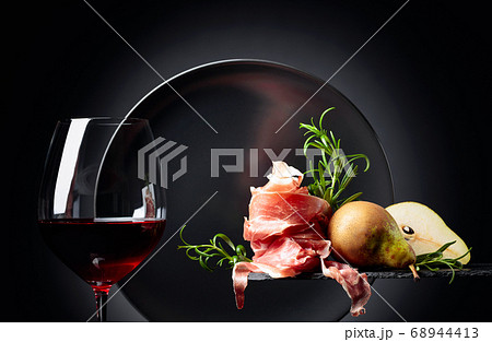 Red wine with prosciutto, pears and rosemary. 68944413