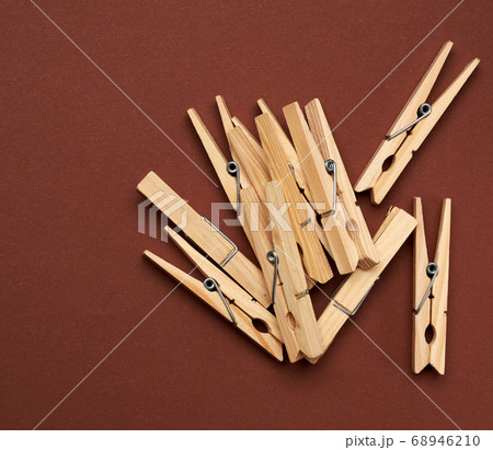 stack of wooden clothespins on brown background 68946210