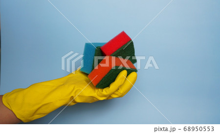 Hand in glove holding few washing sponges - amount of housework concept 68950553