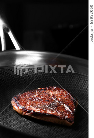 Beef Steak is preparing on the dark pan 68952060