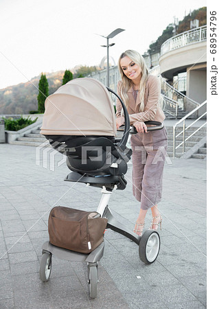 Cute mother with a pram Cute mother with a pram 68954796